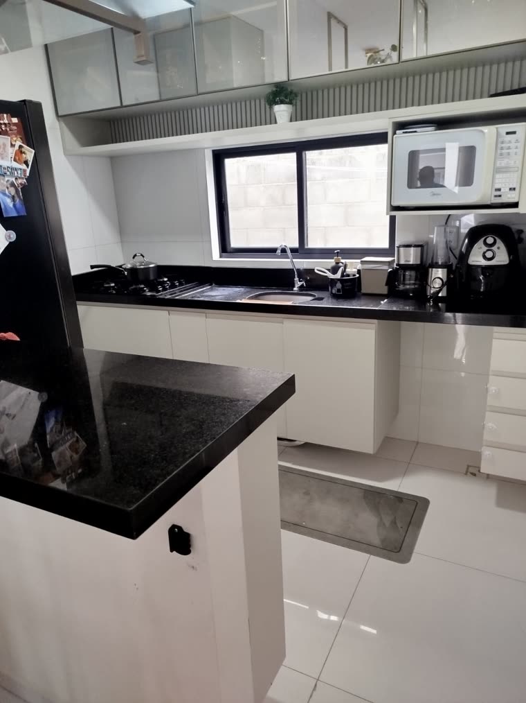 Cozinha vista de dentro, com a península de granito preto